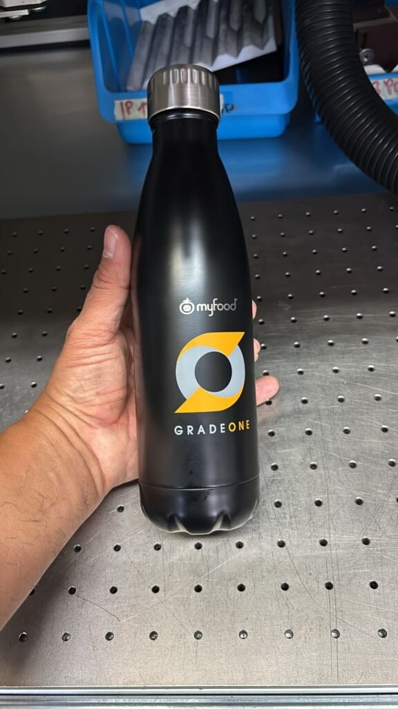 Trinkflasche mit Lasergravur: Firmenlogo myfood GradeOne, schwarze Isolierflasche