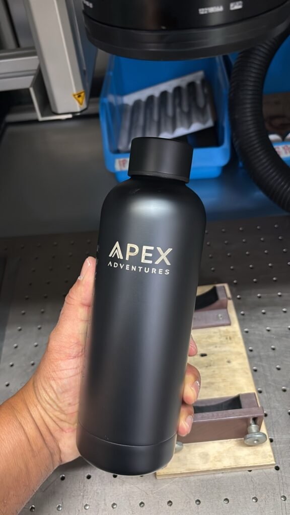Schwarze Isolierflasche mit Lasergravur: Firmenlogo APEX Adventures